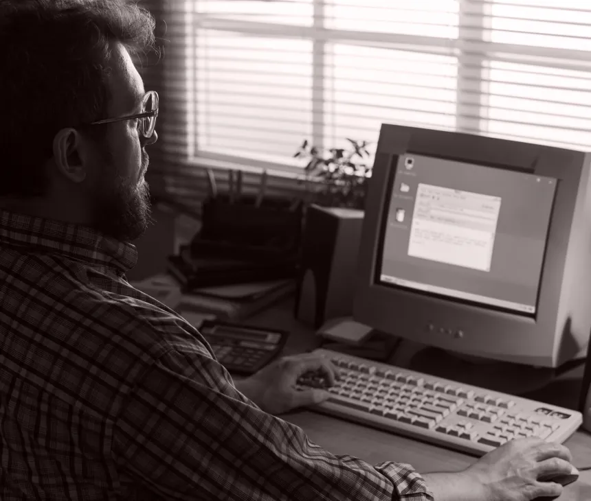 Two engineers at a workstation with an early desktop computer
