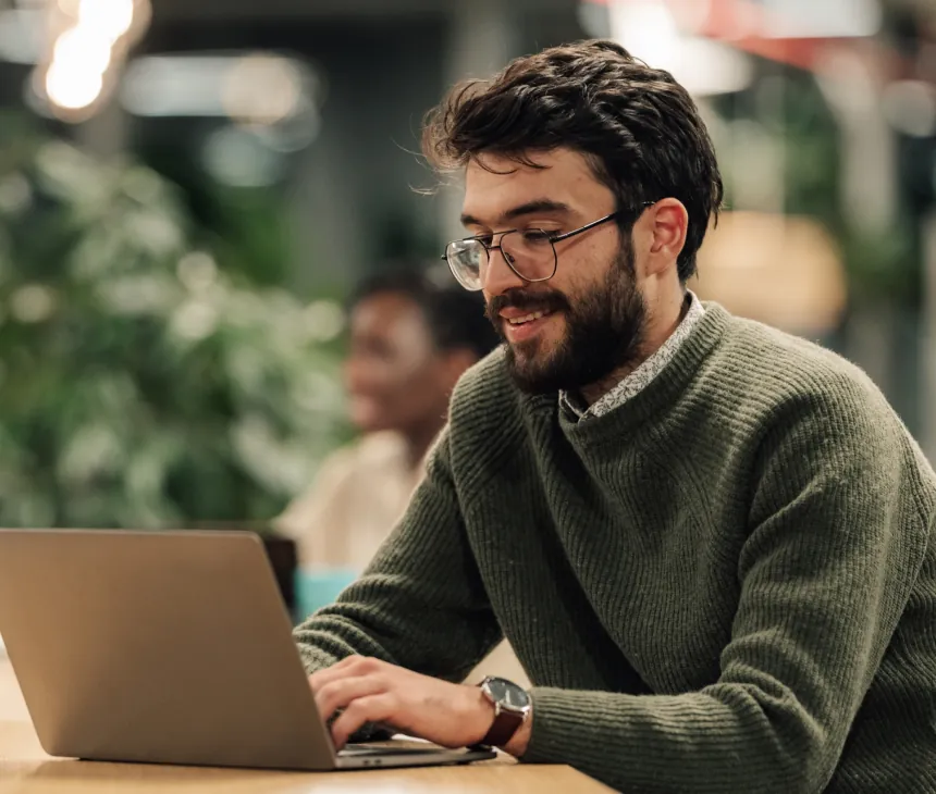 A developer working at a laptop in an open-plan office